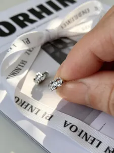 Primer plano de un mini pendiente de aro en plata S925 con diseño tallado brillante