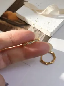 Detailaufnahme eines vergoldeten S925-Silberwellenrings mit funkelnden Steinen