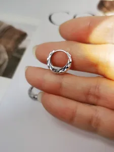 Primer plano de pendiente de aro de plata S925 con diseño de estrella tallada.