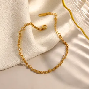 Dettaglio di un bracciale in acciaio inossidabile placcato oro con piccoli cristalli.