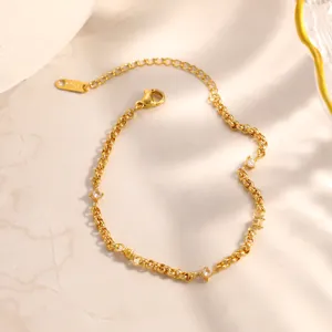 Dettaglio di un bracciale in acciaio inossidabile dorato con piccoli zirconi