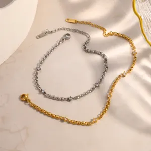 Dettaglio di bracciali in acciaio inossidabile oro e argento con pietre di zircone incastonate.