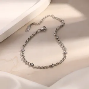 Dettaglio di un bracciale a catena in acciaio inossidabile argento con pietre lucide.