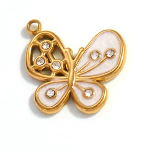 Detailansicht eines goldenen Schmetterlingsanhängers mit weißem Emaille und Strass