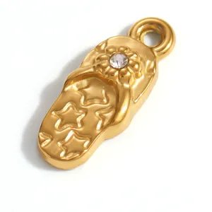 Detailansicht eines goldenen Flip-Flop-Anhängers mit Sternen und einer Kristallblume