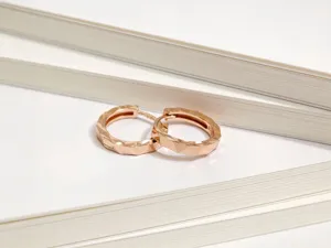 Dettaglio macro degli orecchini a cerchio in argento S925 sfaccettati in oro rosa