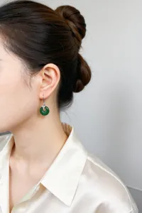Dettaglio orecchini in calcedonio verde indossati da un'elegante modella asiatica