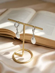 Primo piano di eleganti orecchini a cerchio in argento S925 con pendenti a goccia di pietra bianca
