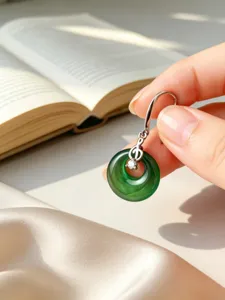 Primer plano de pendiente de plata S925 con nota musical y piedra verde