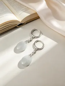 Dettaglio di eleganti orecchini a cerchio in argento S925 con calcedonio a goccia bianco