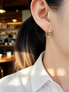 Makroansicht eines minimalistischen S925 Sterling Silber Creolen-Ohrrings am Modellohr