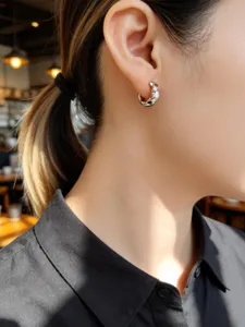 Primo piano di un elegante orecchino a cerchio intrecciato in argento sull'orecchio