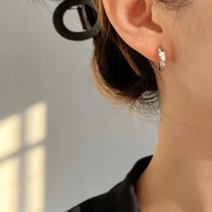 Orecchino a cerchio minimalista in argento sterling S925 mostrato sull'orecchio.