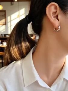 Primer plano de un pendiente de aro de plata S925 con diseño de burbujas en escena