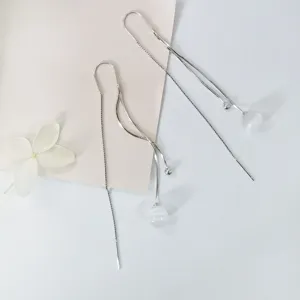 Detailopname van S925 zilveren lange kwastje oorbellen met witte kattenoogsteen.
