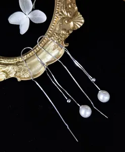 Detailweergave van elegante S925 zilveren kwastjes oorbellen met witte parels op zwart