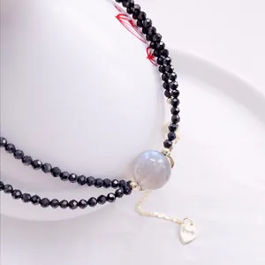 Primo piano di un elegante choker a due fili in spinello nero con perla di labradorite