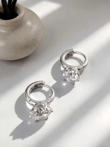 Primer plano de pendientes de aro de plata S925 con detalle de solitario brillante.