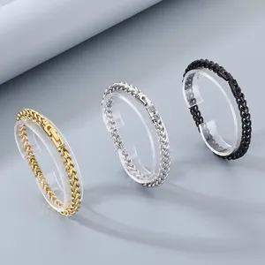 Vista detallada de tres pulseras de cadena de metal minimalistas en oro, plata y negro.