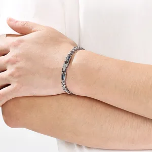 Vista detallada de pulsera de cadena metálica minimalista con cierre cilíndrico giratorio.