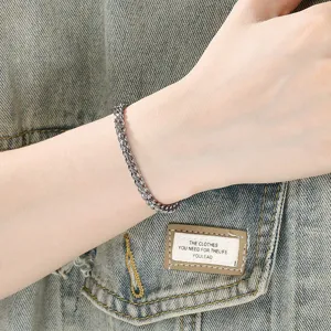 Primer plano detallado de una elegante pulsera de cadena de plata llevada en la muñeca.