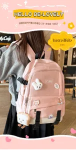 Fille portant un sac à dos rose et crème avec des écussons de dessins animés dans un café.