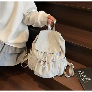 Detailansicht eines modischen hellblauen Nylon-Rucksacks mit schicker MUTING-Stickerei