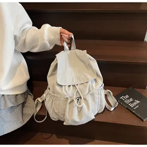 Detailansicht eines hellgrauen Nylon-Rucksacks mit Kordelzug für Schule und Freizeit.