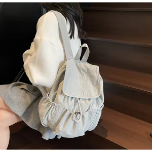 Modischer hellblauer Nylon-Rucksack mit Kordelzug, getragen von einem Model auf Treppen.