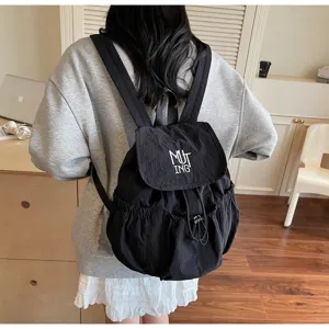 Detailansicht eines schwarzen Nylon-Rucksacks mit Kordelzug und MUTING-Stickerei
