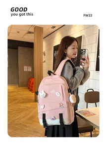 Vue de côté d'un grand sac à dos scolaire rose avec des broches d'animaux mignons