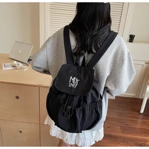 Rückansicht eines minimalistischen schwarzen Nylon-Rucksacks an einem Modell im Zimmer