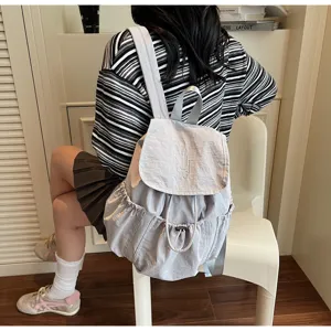 Rückansicht eines hellgrauen Nylon-Rucksacks mit Kordelzug, getragen in lässigem Stil