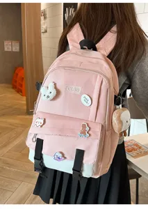 Détail d'un sac à dos scolaire rose et blanc contrasté avec de jolis patchs d'animaux