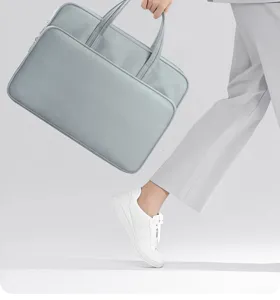 Detailaufnahme der hellgrauen Laptoptasche mit mehrschichtigem Stauraum und robustem Griff.