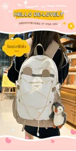 Detailansicht eines großen weißen und khakifarbenen Rucksacks mit niedlichem Pinguin-Anhänger