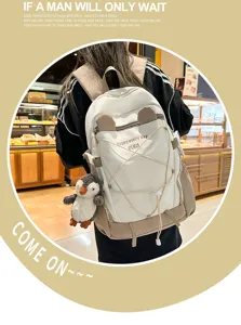 Detailansicht eines weißen Schulrucksacks mit großem Fassungsvermögen und Pinguin-Anhänger