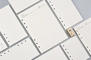 Detailed view of loose-leaf planner refills featuring lined, grid, and dot grid paper layouts.