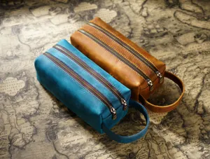 Genuine leather double zipper pencil case detail showing dual compartments and carry handle.