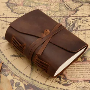 Close-up detail of vintage handmade leather journal notebook with rustic strap closure.