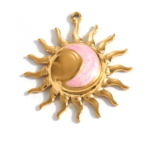 Primo piano di un pendente a sole in acciaio dorato con centro luna in smalto rosa