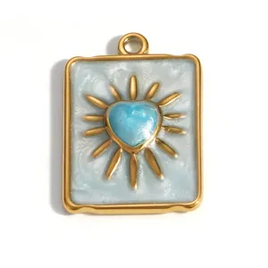 Dettaglio di un ciondolo a cuore in acciaio inossidabile dorato con smalto blu e raggi