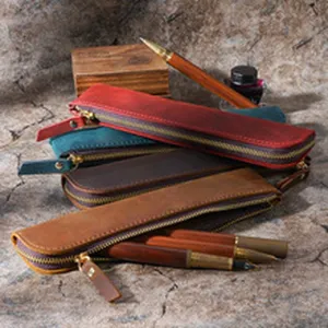Handmade vintage leather pencil case detail view, retro style stationery pouch holder.