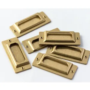 Nahaufnahme von Retro-Messing-Etikettenhaltern und Metall-Hardware-Details für Schubladen.