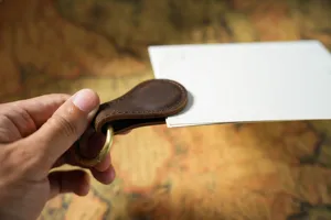 Close-up of genuine leather magnetic clip showcasing vintage brown texture and metal ring.
