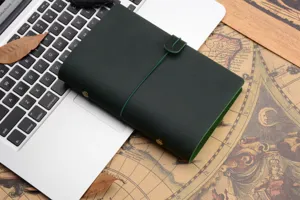 Vintage dark green leather notebook journal travelers diary with elastic band and button closure.
