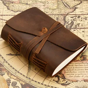 Handmade vintage leather journal with strap closure, retro brown notebook for sketching daily notes.
