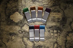 Detailed view of multi-color embossed leather metal money clips and bookmarks on vintage map.