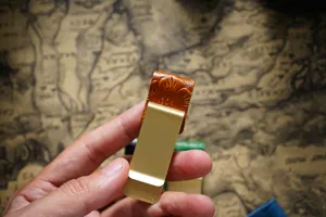 Brass metal money clip with carved leather pen holder, vintage retro style notebook accessory.