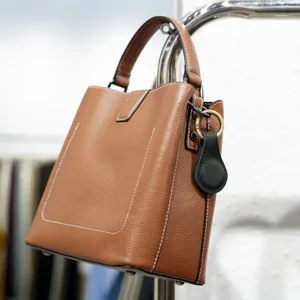 Premium brown leather handbag with durable top handle and contrast stitching for daily fashion use.
